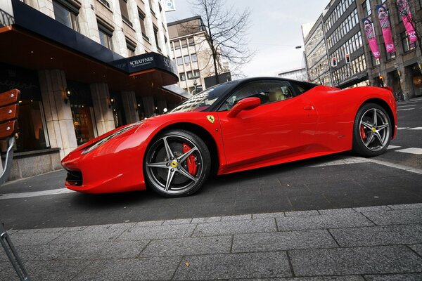 Coche ferrari 458 italia rojo en la calle de la ciudad