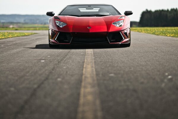 Lamborghini rojo en una carretera pavimentada