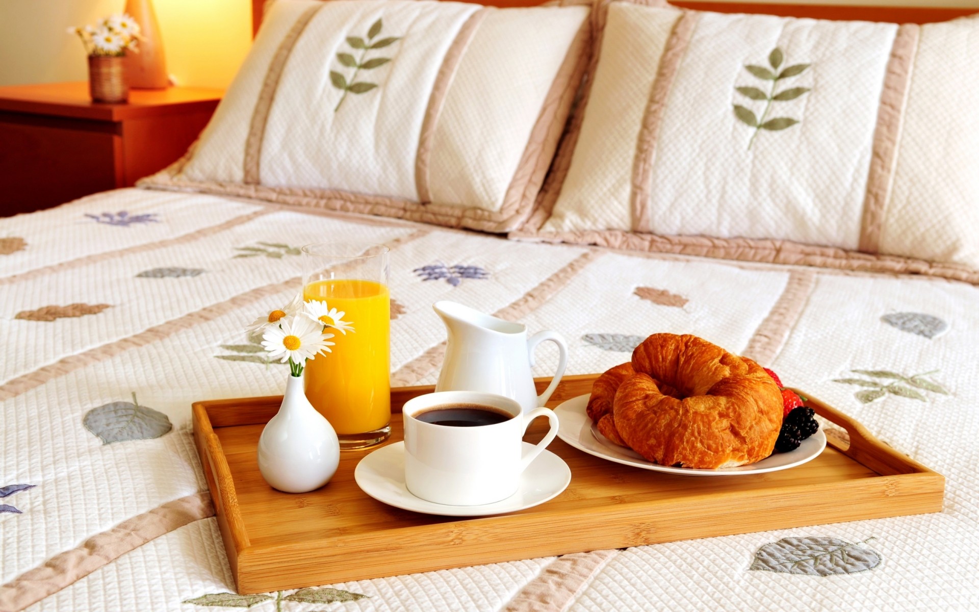 cama bandeja taza café jugo flores almohadas florero