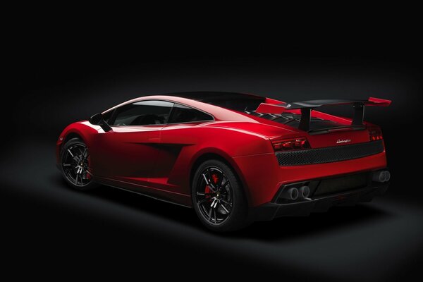 The back of a red lamborghini on a black background