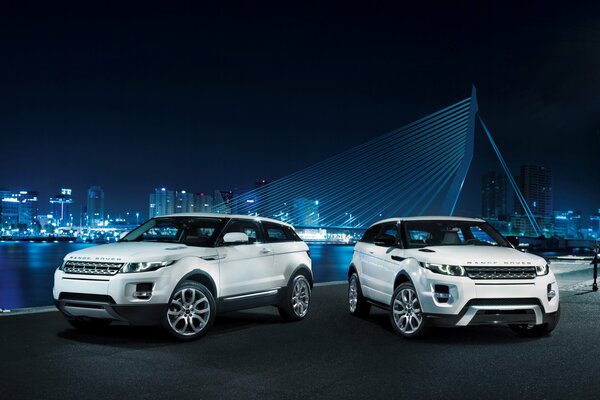 Land Rover blanc sur fond de ville de nuit