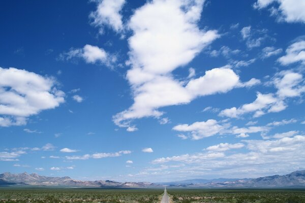 La strada che cade in lontananza che decora il cielo tra le nuvole