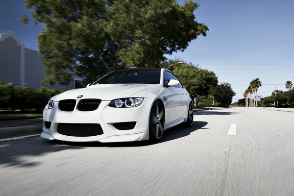 Blanc BMW chevauche la route tout droit