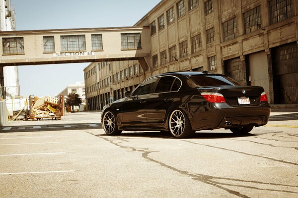 Black BMW with tinted windows in an industrial area