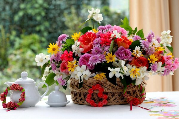 Composición de geranios, rosas y jazmín en la mesa