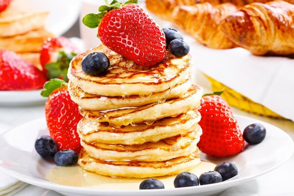 Frittelle e croissant mattutini con miele e frutti di bosco