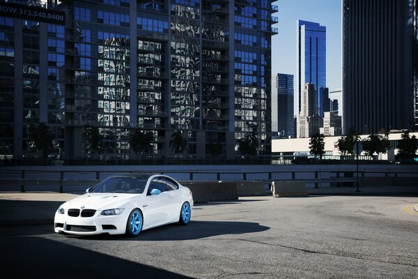 White BMW in the parking lot against the background of the city