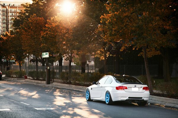 White BMW on blue discs on the street