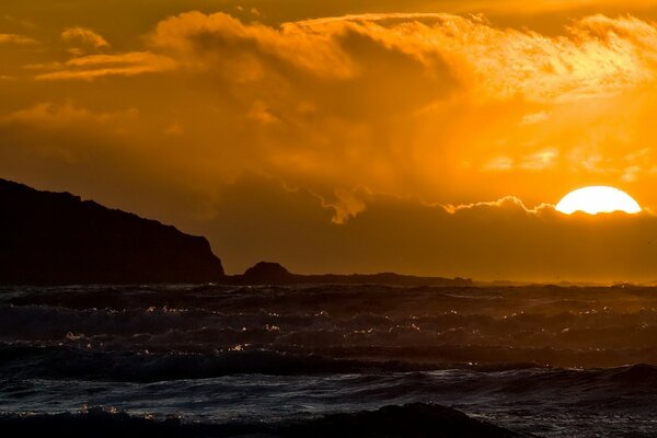 Sunset in a cloud on the background of the sea