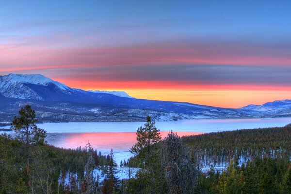 Winter lake with mountains at sunset