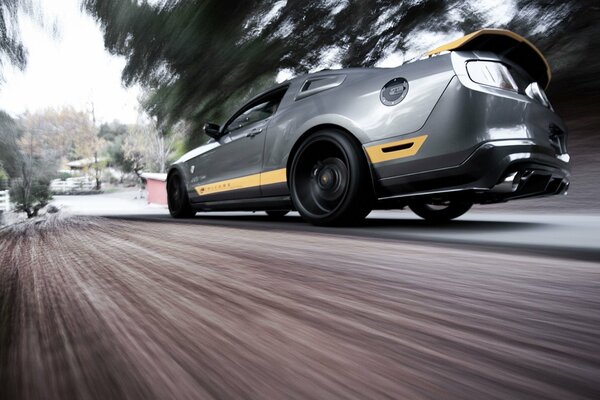 Ford Mustang in gray is racing at speed