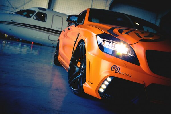 Voiture orange près de l avion blanc