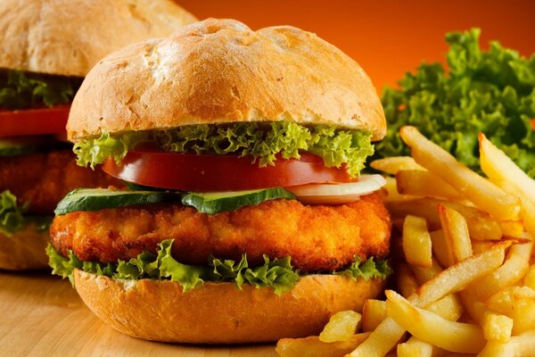 Köstlicher Burger mit Salatblättern, saftigem Schnitzel, Gurken und Tomaten