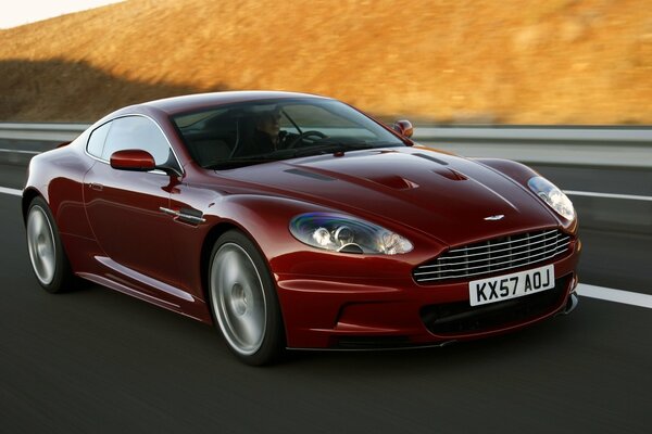 La voiture de couleur Bordeaux prend de la vitesse