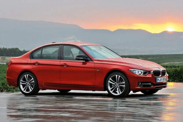 On wet asphalt - red boomer, sunset in the background