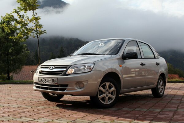 Lada Granta grigio sullo sfondo delle montagne