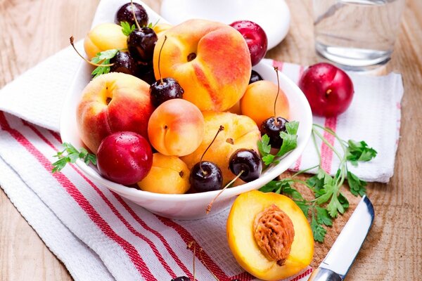 Pfirsiche und Pflaumen in einem Teller. Obst auf dem Tisch