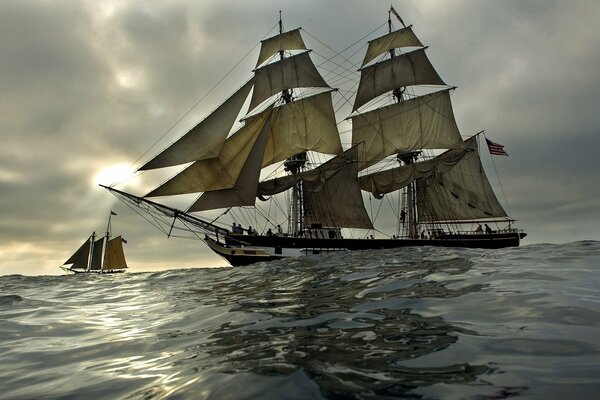 Ships and sailboats at sea against the background of the evening sky