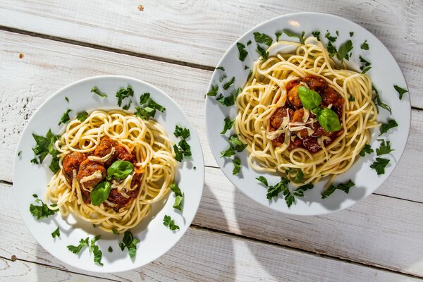 Spaghetti bolognese z ziołami na talerzach