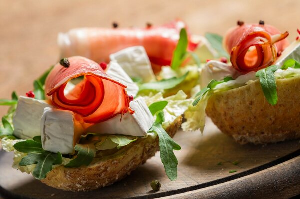 Antipasto a forma di barca di pane con formaggio, prosciutto ed erbe aromatiche