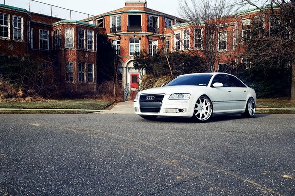 A white Audi is parked at a rich house