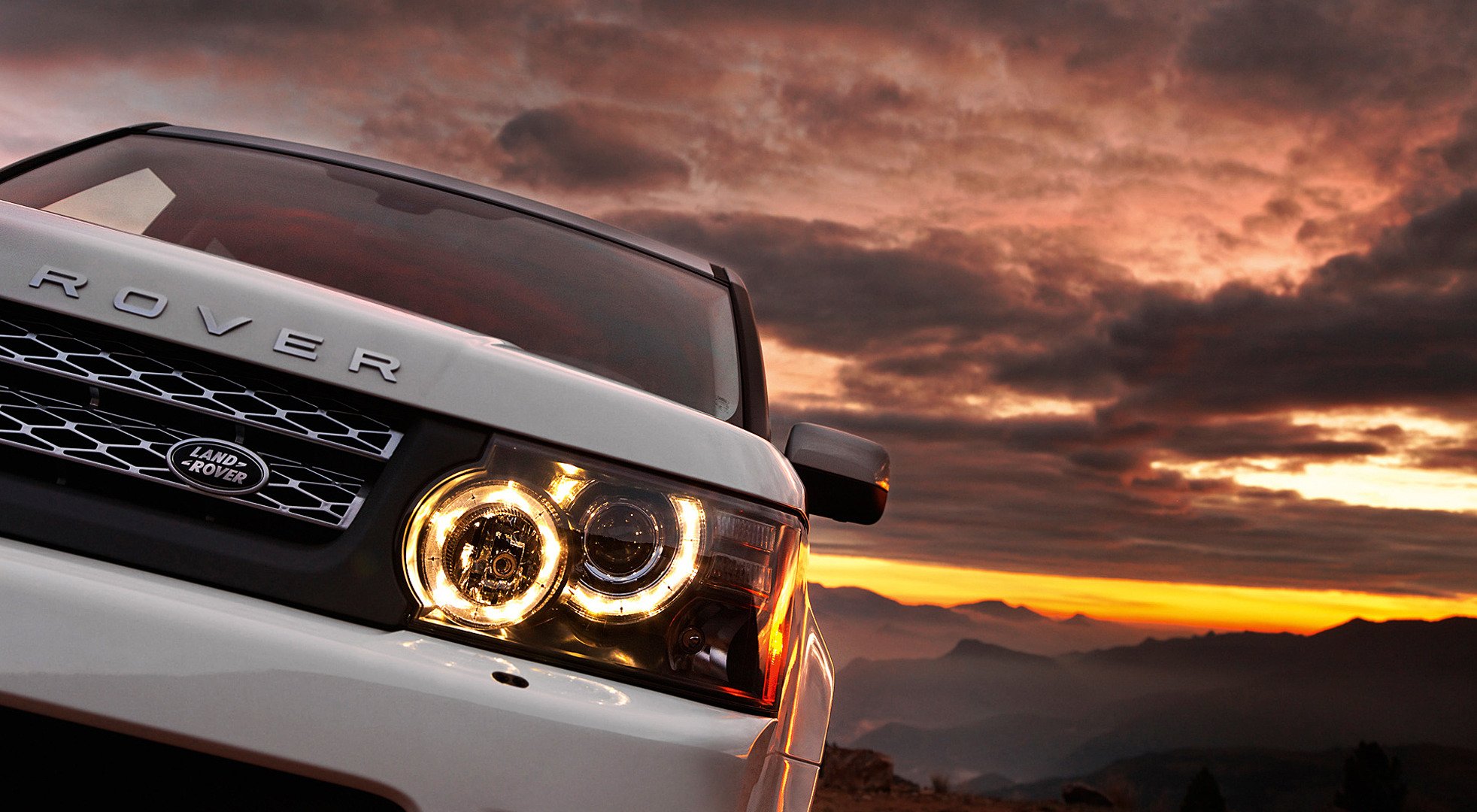 range rover blanc auto coucher de soleil montagnes