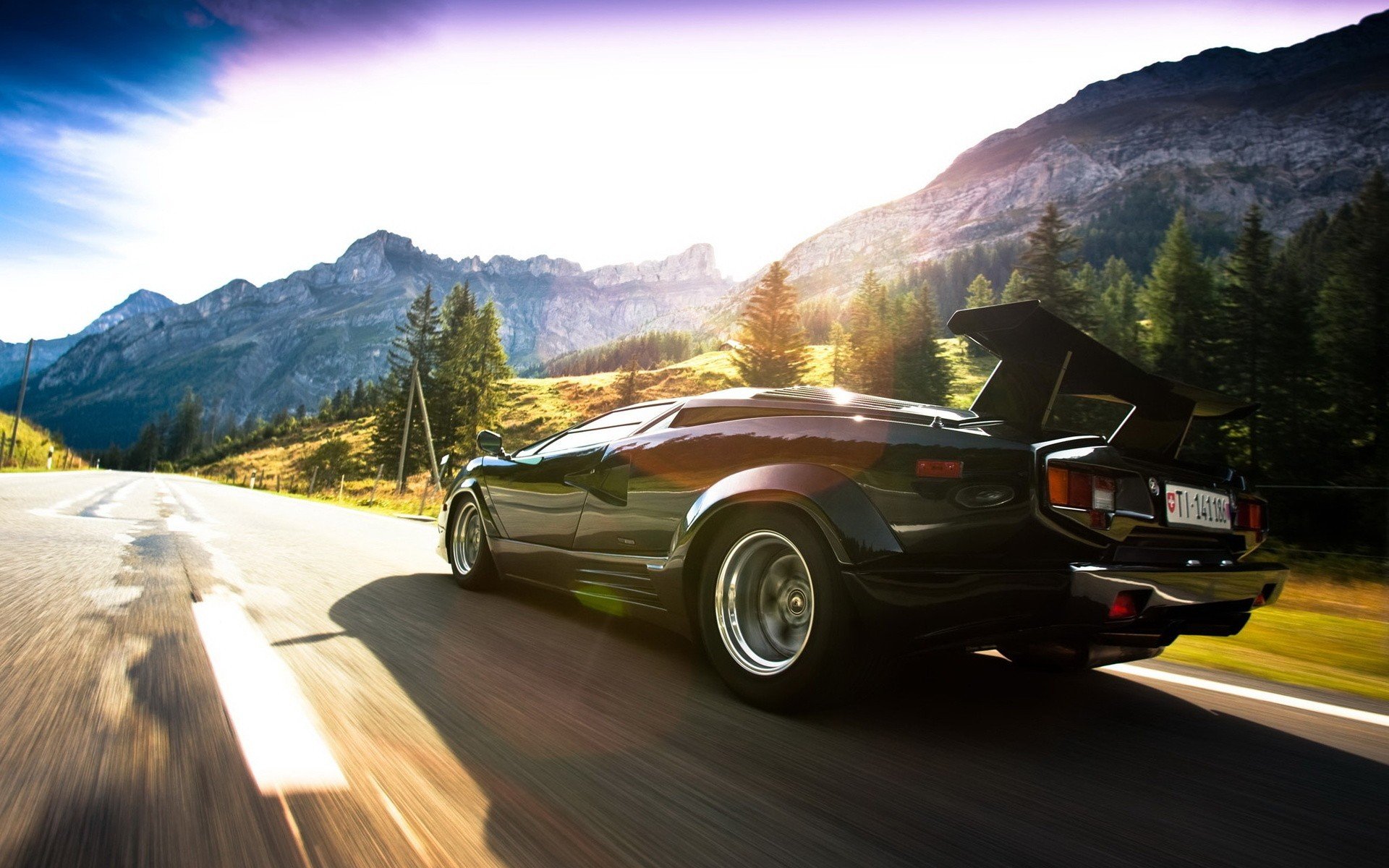 lamborghini lamborghini countach speed light sun clouds sky aswalt road mountains rocks glare tree