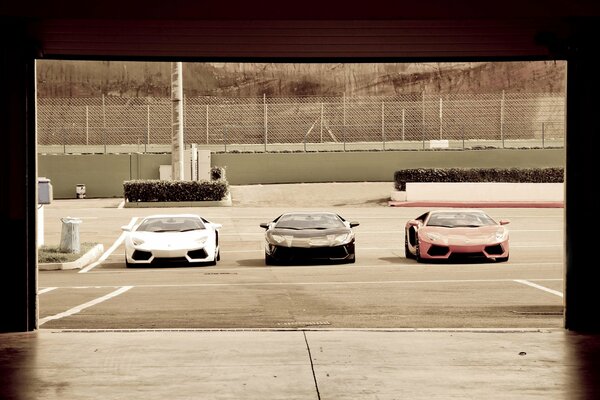 Three Lamborghini in the parking lot under the scorching sun 