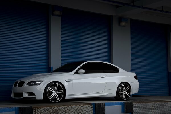 A beautiful white BMW is reflected on a dark background 