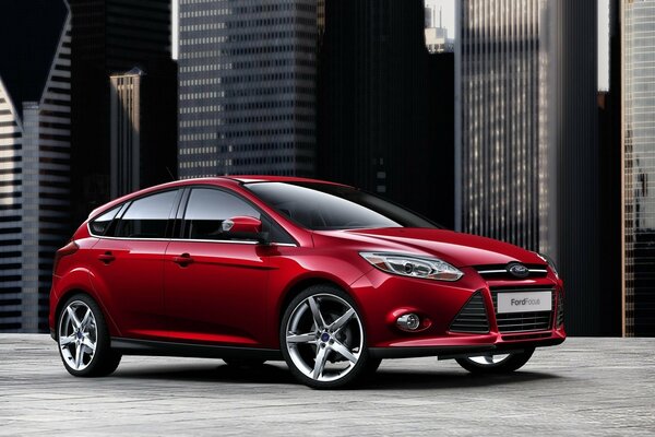 Coche rojo en el fondo de los edificios de la ciudad