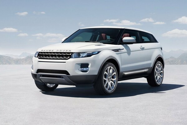 White range rover in the mountains in winter