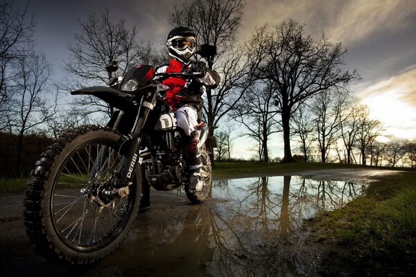 Motorrad auf dem Hintergrund der herbstlichen Natur in der Nähe von Pfützen