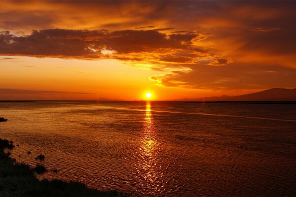 Tramonto arancione brillante sulla spiaggia