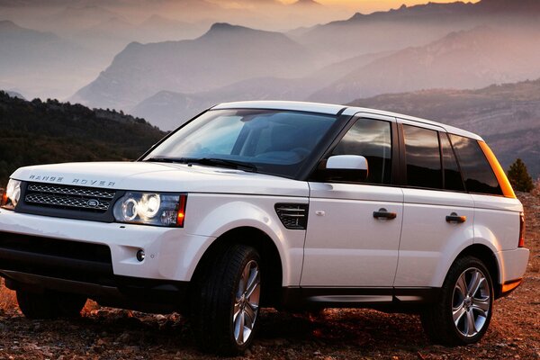 Chic white jeep range rover at sunset in the mountains