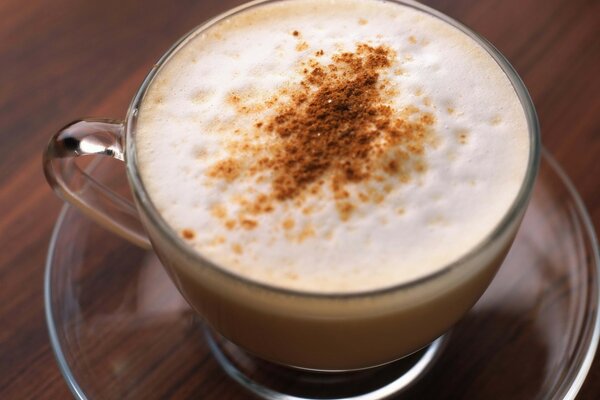 Café dans une tasse avec de la cannelle et de la mousse