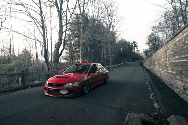 Lancer rojo sobre fondo de asfalto mojado