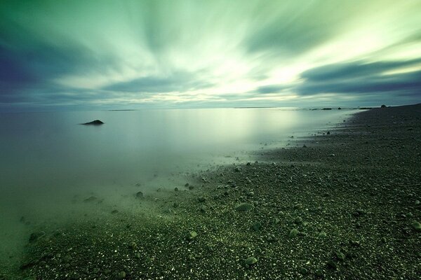 The stone shore and the light making its way through the clouds