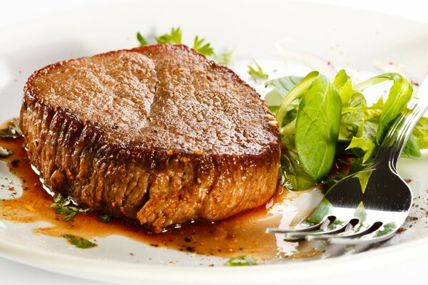 Chop with herbs on a plate with a fork