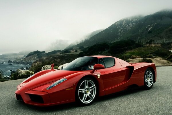 Ferrari deportivo rojo en el fondo de las montañas