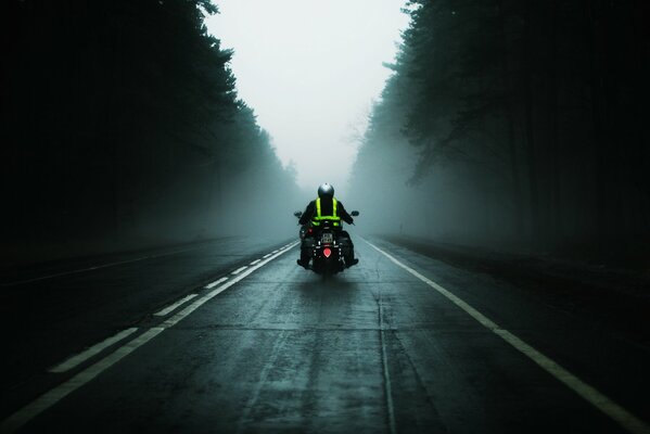 Una motocicleta con un hombre monta en la carretera