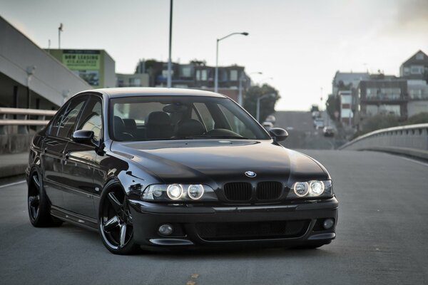 Black BMW on the bridge in the city