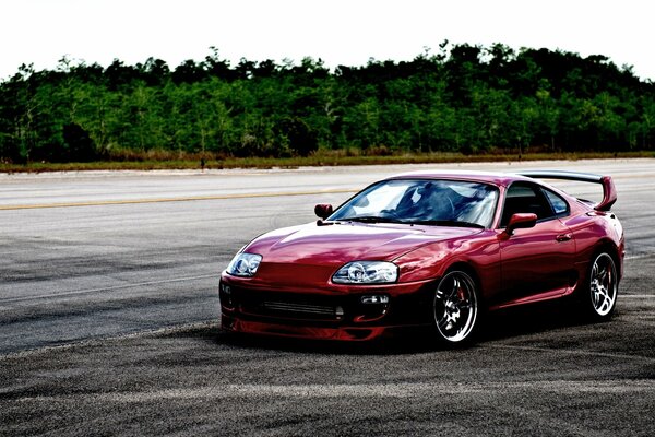 A maroon car on an empty road