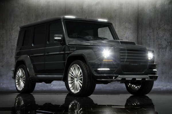 Mercedes-Benz on wet asphalt against a concrete wall