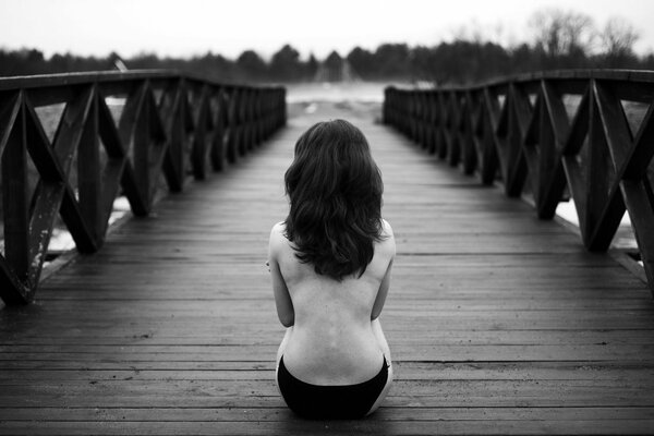 Lonely girl on a wooden bridge