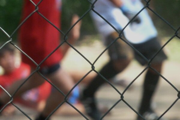 Chicos patean una pelota en la calle