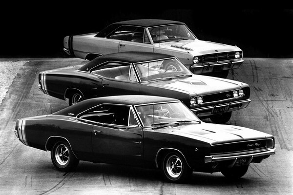 Three retro muscle cars on a dark background