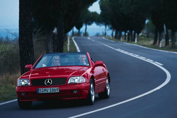 Coche rojo de Mercedes Benz en el camino