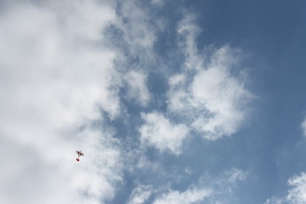 A plane on a background of white clouds and blue sky