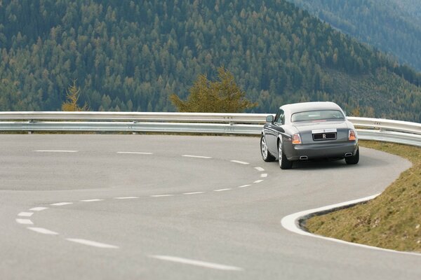 Rolls Royce on a sharp turn among the green mountains