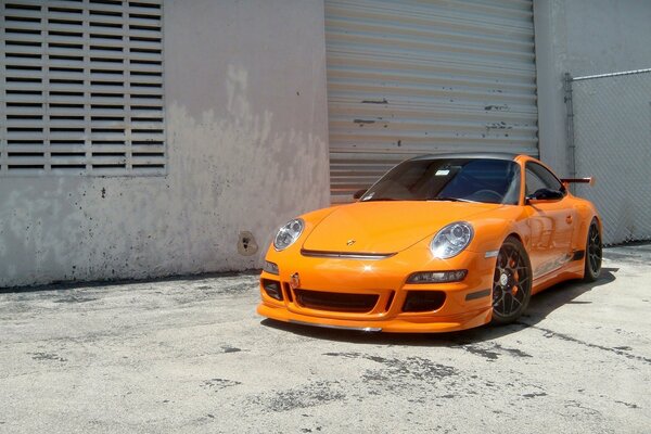 Ein orangefarbener Porsche in den Hinterhöfen der Stadt